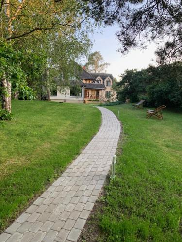a cobblestone path in front of a house at Nordes in Ragaciems