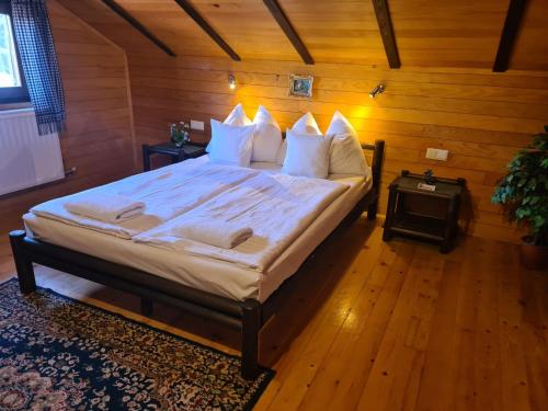 a bedroom with a large bed with white sheets and pillows at Kosmajski vajati Petra in Nemenikuće