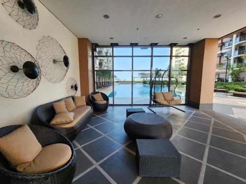 a living room with couches and chairs and a pool at Galini Suites in Manila