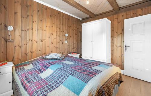 a bedroom with a bed and wooden walls at Awesome Home In Rjukan With Wifi in Rjukan