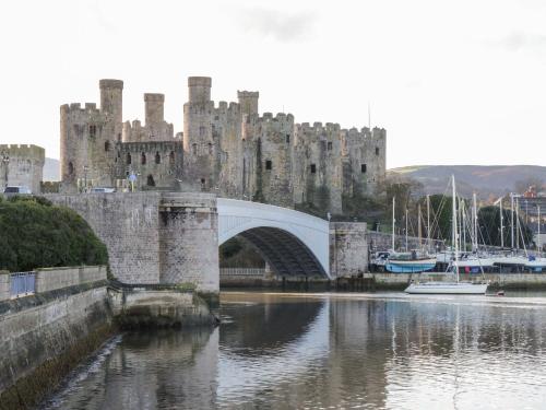 a castle with a bridge over a body of water at 3 York Place in Conwy
