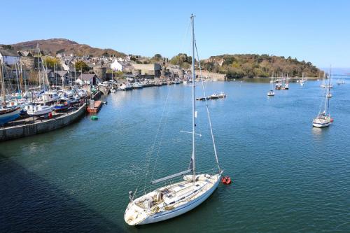 a sailboat is docked in a harbor with other boats at 3 York Place in Conwy