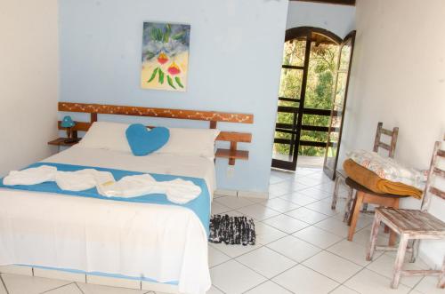 a bedroom with a bed with a blue heart on it at Pousada Aconchego Shangrilla in Penedo
