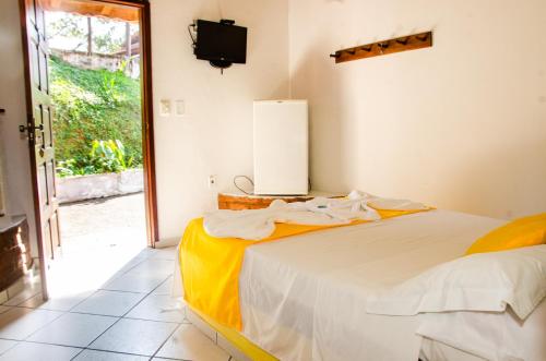 a bedroom with a bed and a tv and a window at Pousada Aconchego Shangrilla in Penedo