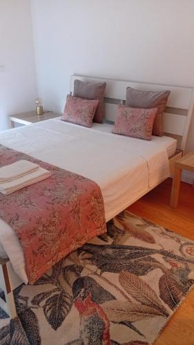 a bed with two pillows on it in a room at Apartamento LUZ DA PRAIA in Vila Chã