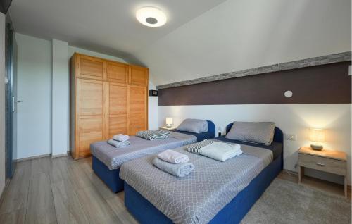 a bedroom with two beds with towels on them at 2 Bedroom Cozy Home In Duga Resa in Duga Resa