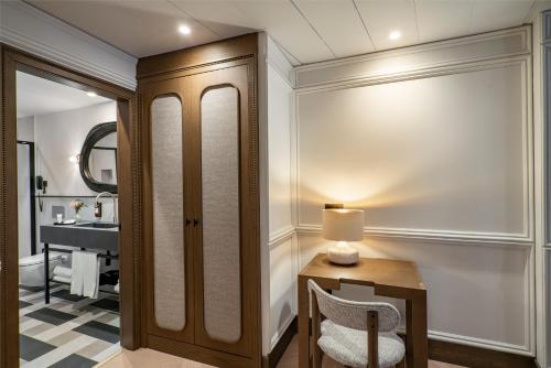 a bathroom with a vanity and a table with a chair at Vincci Soho in Madrid