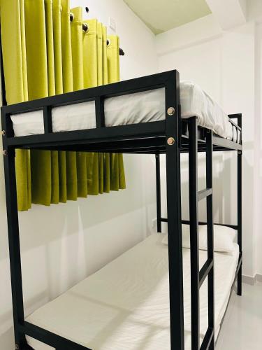 a black bunk bed in a room with pipes at Browns Beach Hostel Negombo in Negombo