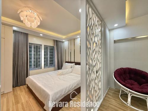 a bedroom with a bed and a chair and a window at Nevara Residence Hue in Cồn Giả Viên