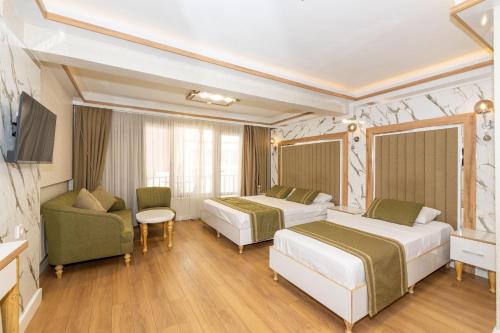a hotel room with two beds and a couch at TAKSİM HAVANA HOTEL SUİTES in Istanbul