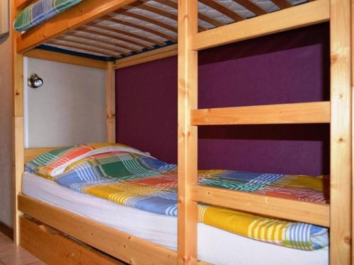 - un lit superposé en bois avec une couette colorée dans l'établissement Appart. cosy 2 pièces, 6 pers, terrasse, garage, proche pistes - Le Grand-Bornand - FR-1-241-25, au Grand-Bornand