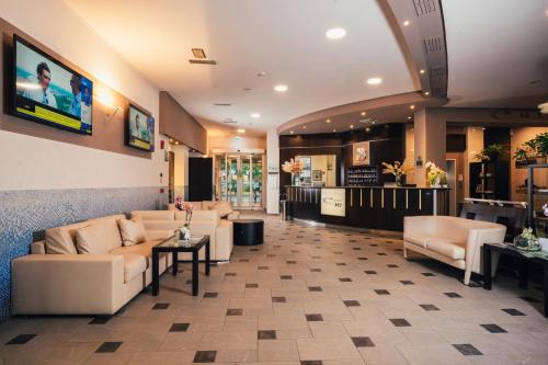 a waiting room with couches and tables and a tv at Euro Hotel in Imola