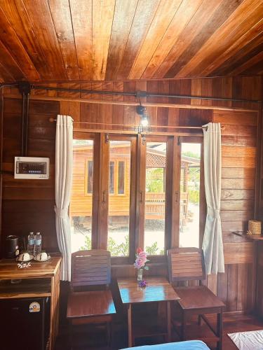 ヤオヤイ島にあるLaleuca At Laemhad Kohyaoyaiのテーブルと椅子と窓のあるダイニングルーム