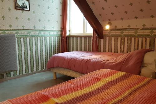 a bedroom with two beds and a window at Maisons agréables 13ms023 in La Fresnais
