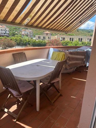 a table and chairs on a balcony with a bed at La Locanda della Vecchia Hosteria in Gavorrano