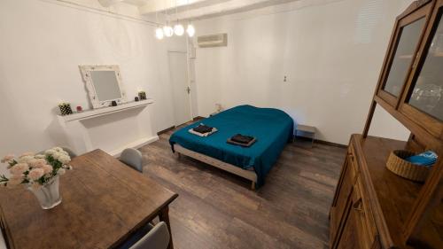 a bedroom with a bed in a room with a table at Appartement de village in Monacia-dʼAullène