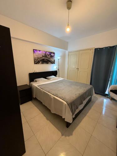 a bedroom with a bed and a painting on the wall at Quarto de casal in Costa da Caparica