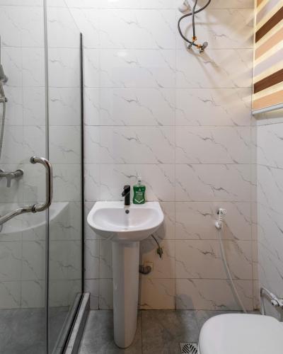 a bathroom with a sink and a shower and a toilet at Topaz Ologolo, Lekki in Lekki