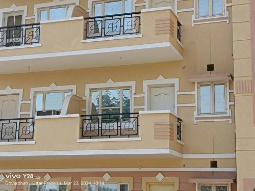 a facade of a building with windows and balconies at Home Stay with Giriraj View I On Parikrama Marg I 5 mins to ISKCON & Daan Ghati in Govardhan