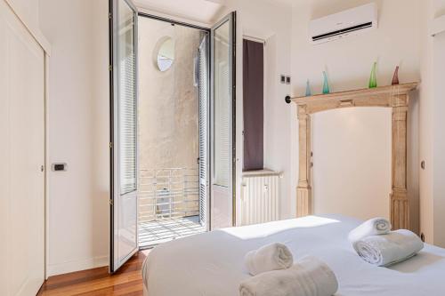 a bedroom with a white bed and a large mirror at Appartamento a 5 stelle con idromassaggio con 2 camere da letto in Milan