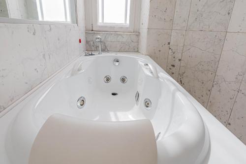 a white bath tub in a bathroom with a window at Appartamento a 5 stelle con idromassaggio con 2 camere da letto in Milan