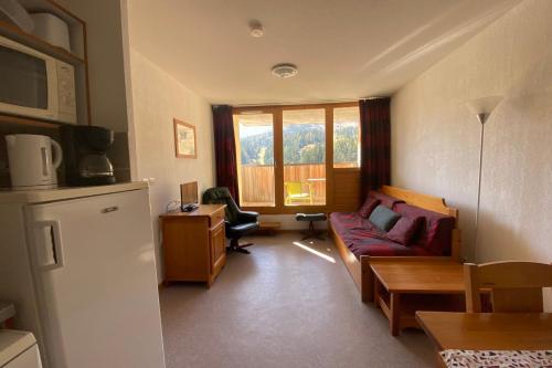 un salon avec un canapé et une fenêtre dans l'établissement Pretty 35 m at the foot of the ski slopes, à Saint-Étienne-en-Dévoluy