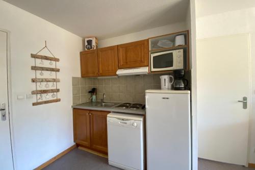 La cuisine est équipée d'un réfrigérateur blanc et d'un four micro-ondes. dans l'établissement Pretty 35 m at the foot of the ski slopes, à Saint-Étienne-en-Dévoluy