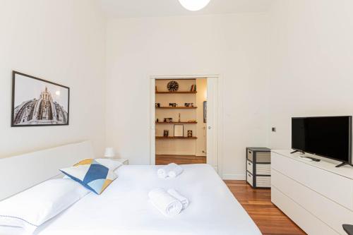 a white bedroom with a white bed and a flat screen tv at Appartamento a 5 stelle con idromassaggio con 2 camere da letto in Milan