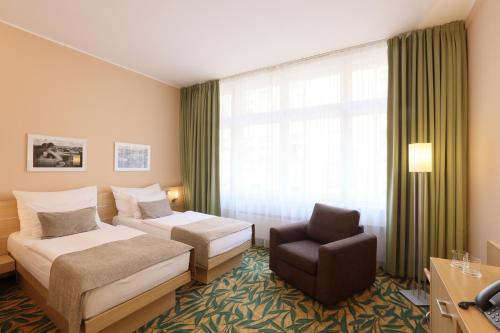 a hotel room with two beds and a chair at Amarilis in Prague