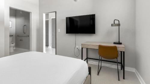 a bedroom with a bed and a desk with a television at Landing at The 600 - Birmingham in Birmingham