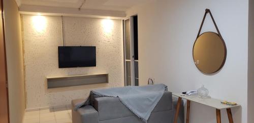 a living room with a couch and a tv on a wall at Ap no Turu, 10 min das praias in São Luís