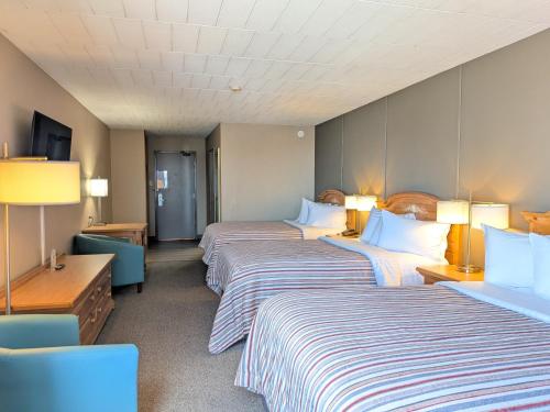 a hotel room with two beds and two lamps at Confederation Place Hotel in Kingston