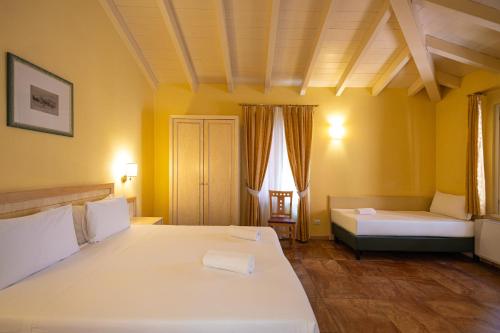a large bedroom with two beds and a couch at Hotel Belvedere San Gottardo by LVG Hotel Collection in Verbania
