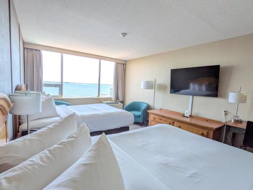 a hotel room with two beds and a flat screen tv at Confederation Place Hotel in Kingston