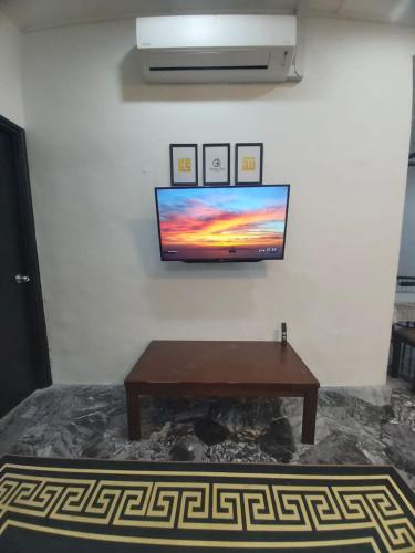 a living room with a table and a tv on the wall at Homestay Fikrah Taman Marida Senawang Musleem Only in Seremban
