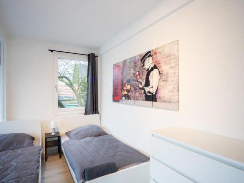 a bedroom with two beds and a painting on the wall at Monteurwohnung-fuer-5-Personen-mit-Balkon-Kueche-Ahrensburg-Naehe-Hamburg in Ahrensburg