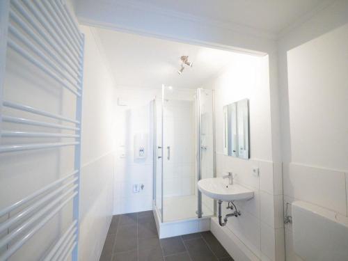 a white bathroom with a shower and a sink at Monteurwohnung-fuer-5-Personen-mit-Balkon-Kueche-Ahrensburg-Naehe-Hamburg in Ahrensburg