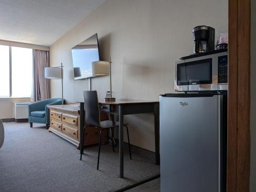 a hotel room with a desk and a refrigerator at Confederation Place Hotel in Kingston
