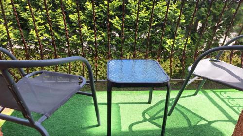 two chairs and a blue chair sitting next to a fence at Rafa in Trzęsacz