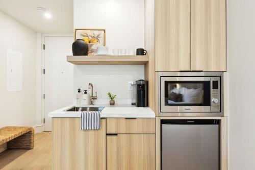 a kitchen with a sink and a microwave at Casa Riviera - Boutique Suites in Downtown Santa Barbara in Santa Barbara