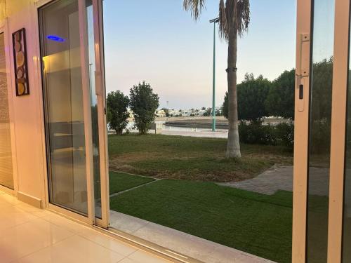 an open glass door with a view of a palm tree at شاليه درة العروس in Jeddah