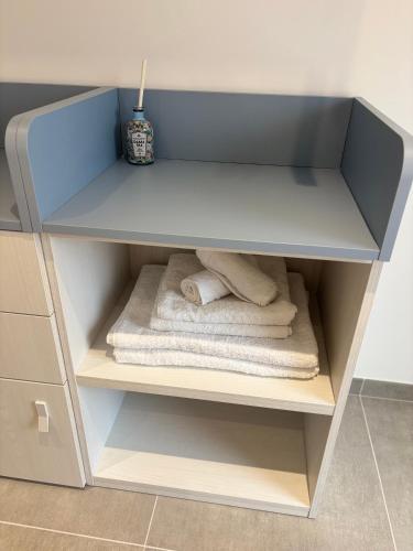 a white cabinet with towels and a alarm clock in it at La Pulvarera in Castelsardo