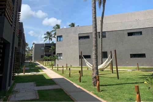 a building with a hammock in front of a building at Vilas Manatee - Praia do Patacho in Pôrto de Pedras