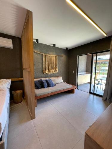 a living room with a bed and a window at Paraíso no patacho - Rota de Milagres in Pôrto de Pedras