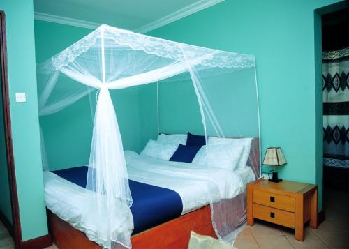 a bedroom with a bed with a canopy at Ngorongoro Villa and Restaurant in Karatu