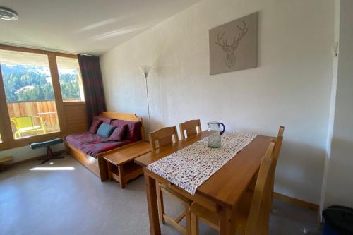 un salon avec une table et un canapé dans l'établissement Pretty 35 m at the foot of the ski slopes, à Saint-Étienne-en-Dévoluy