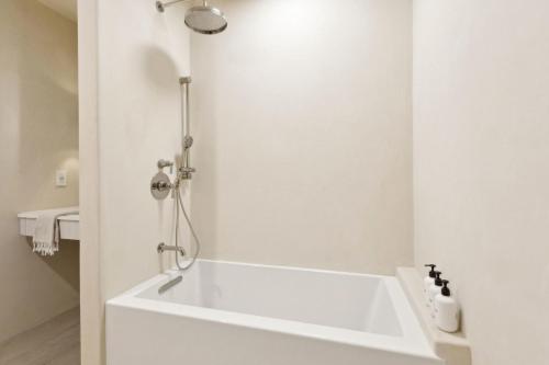 a white bathroom with a tub and a shower at Casa Riviera - Boutique Suites in Downtown Santa Barbara in Santa Barbara