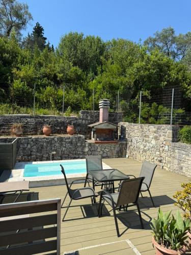 a patio with chairs and a table and a pool at Christina Apartment in Mesochórion