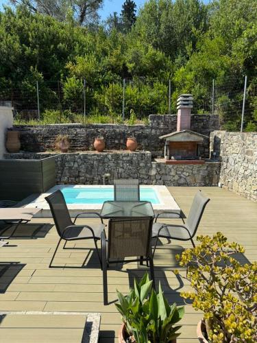 a patio with a table and chairs and a pool at Christina Apartment in Mesochórion