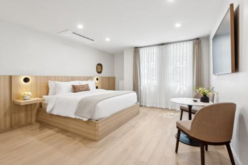 a bedroom with a large bed and a table at Casa Riviera - Boutique Suites in Downtown Santa Barbara in Santa Barbara